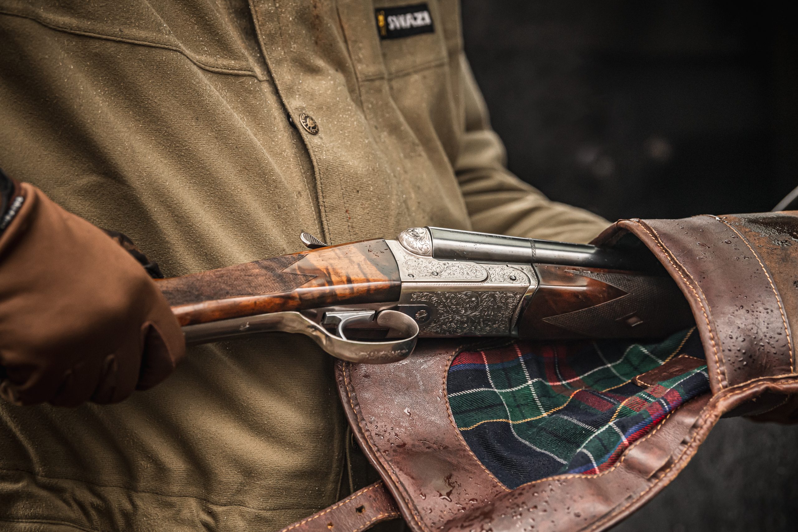 Man pulling side by side shotgun out of a gunslip