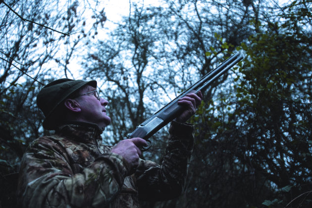 man shooting in wood