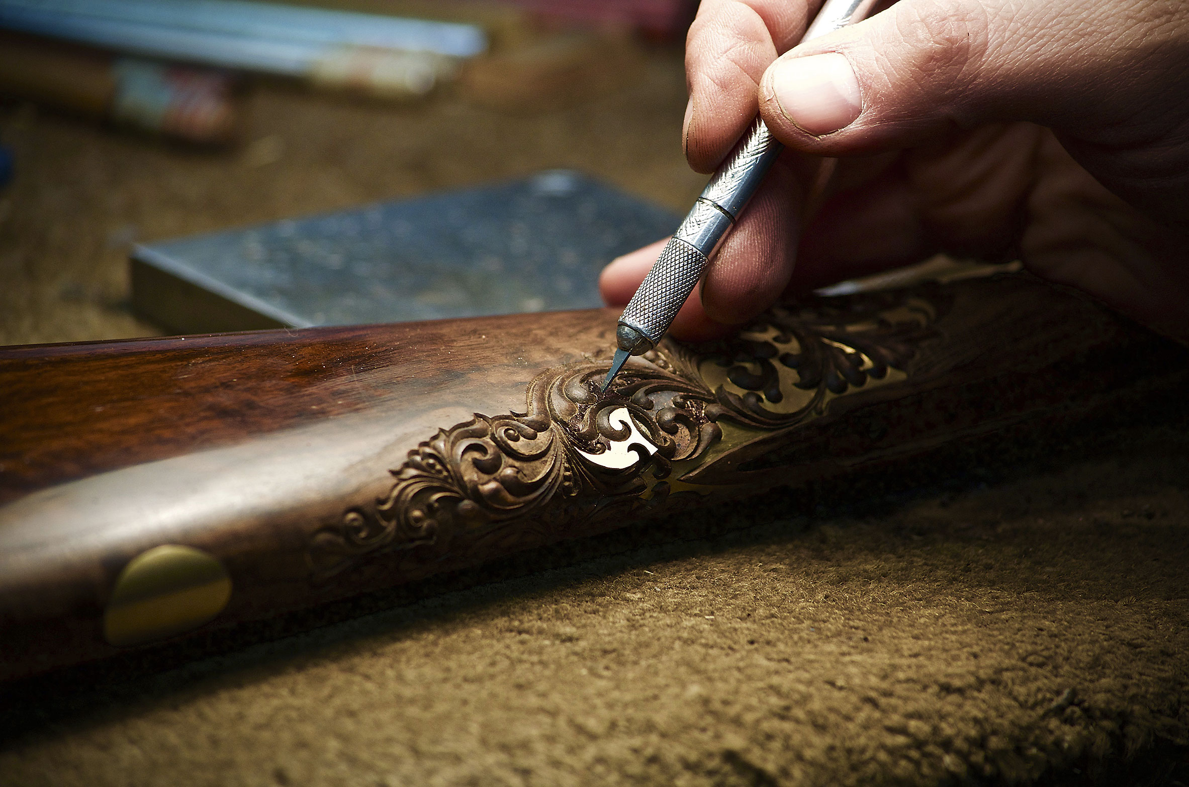 Ron Buck inlays gold leaf onto a carved stock.