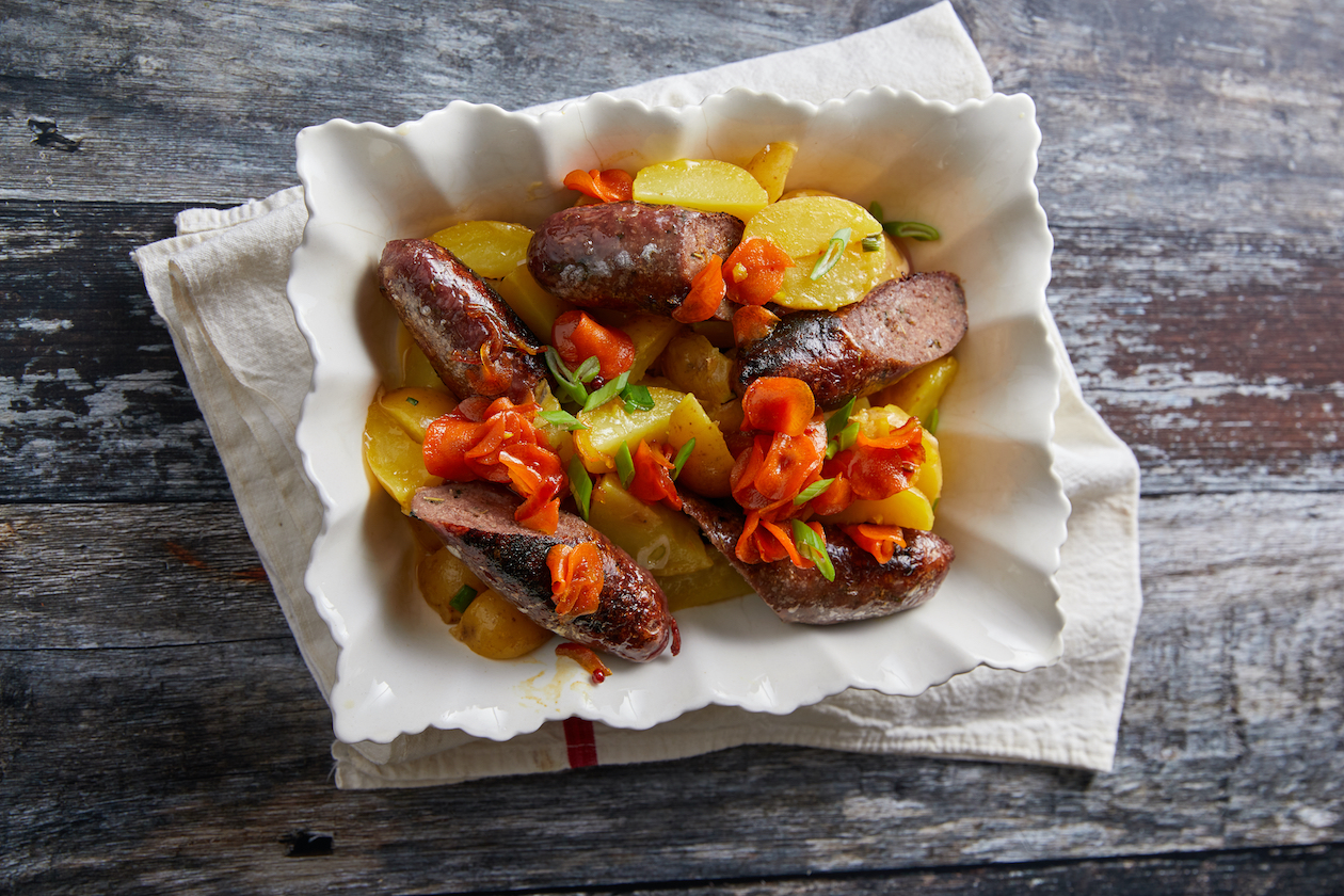 Venison sausages with warm potato salad and pickled carrot