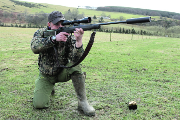 man kneeling with rifle