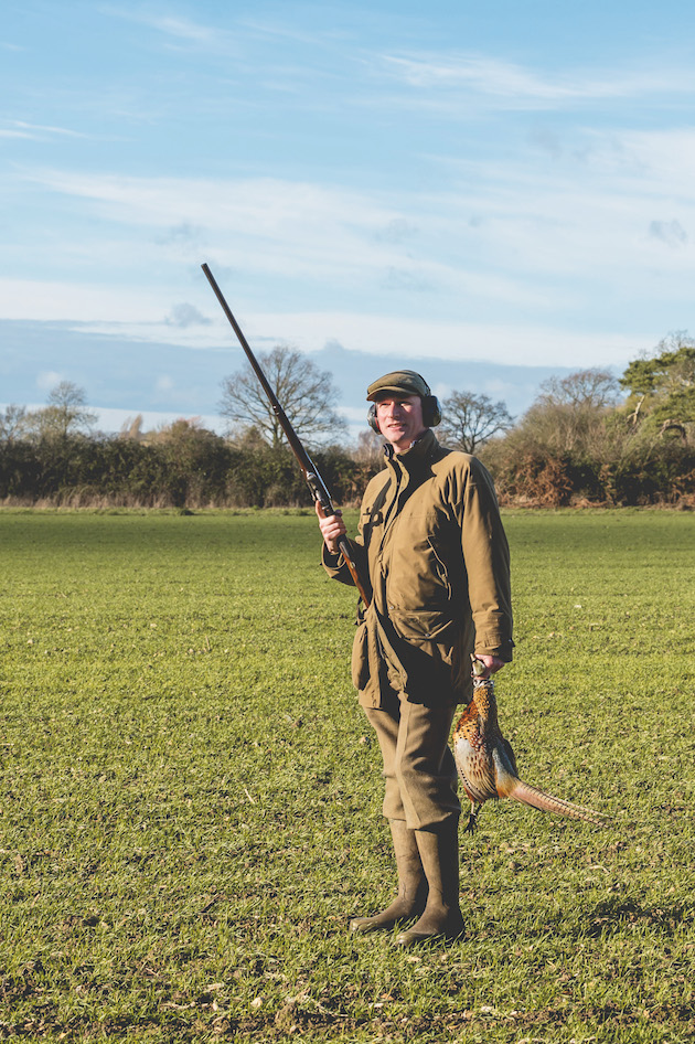 Shooter in field with pheasant