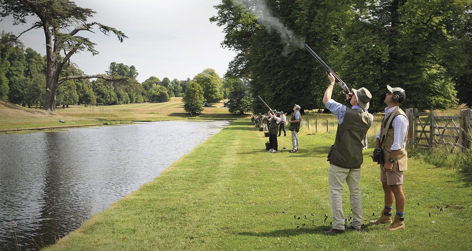 A line of Guns spaced along an ornamental lake on a simulated game day at Boughton