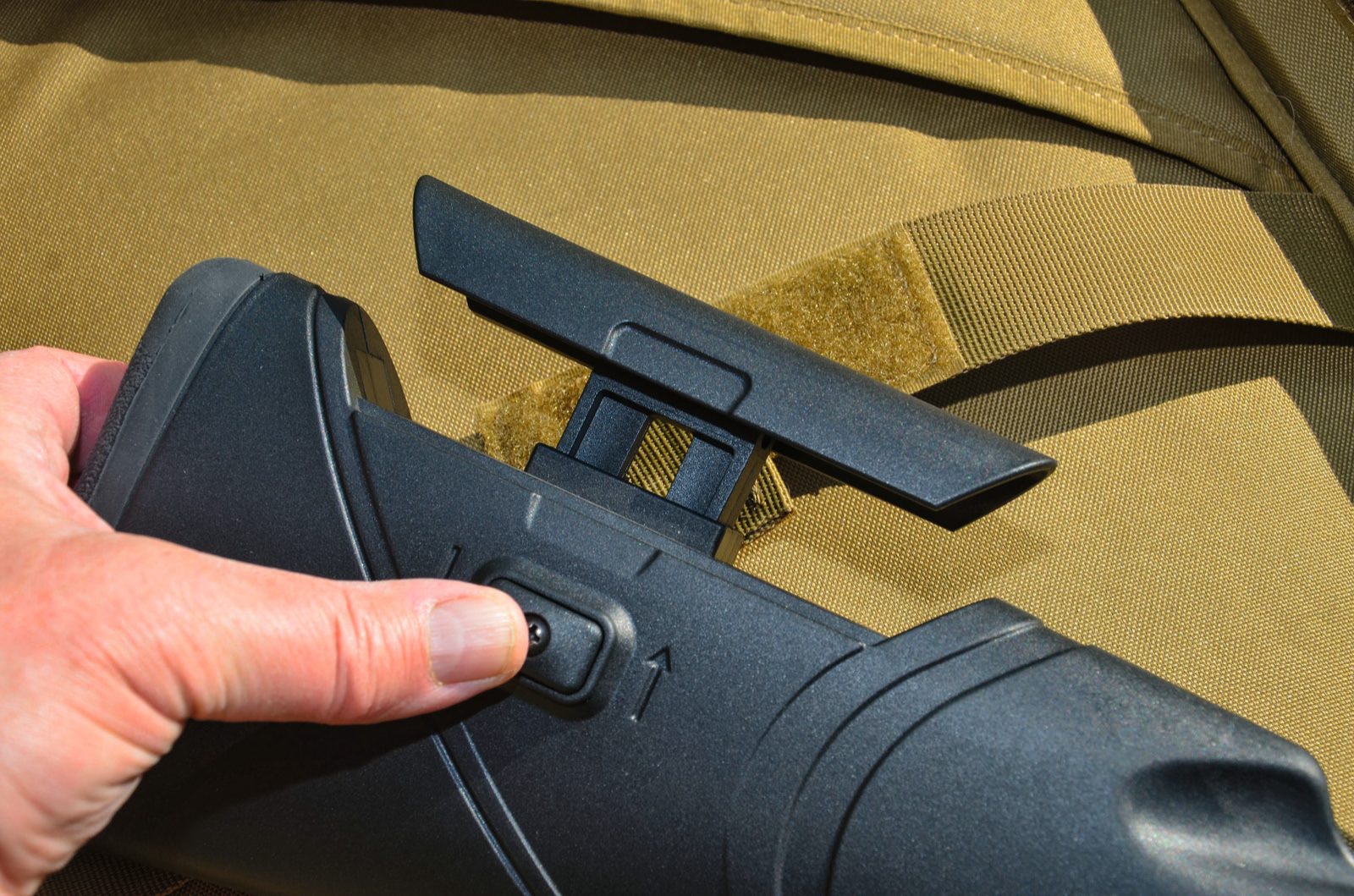 Spring-loaded button raising the adjustable cheekpiece on the EB Arms Agincourt Synthetic