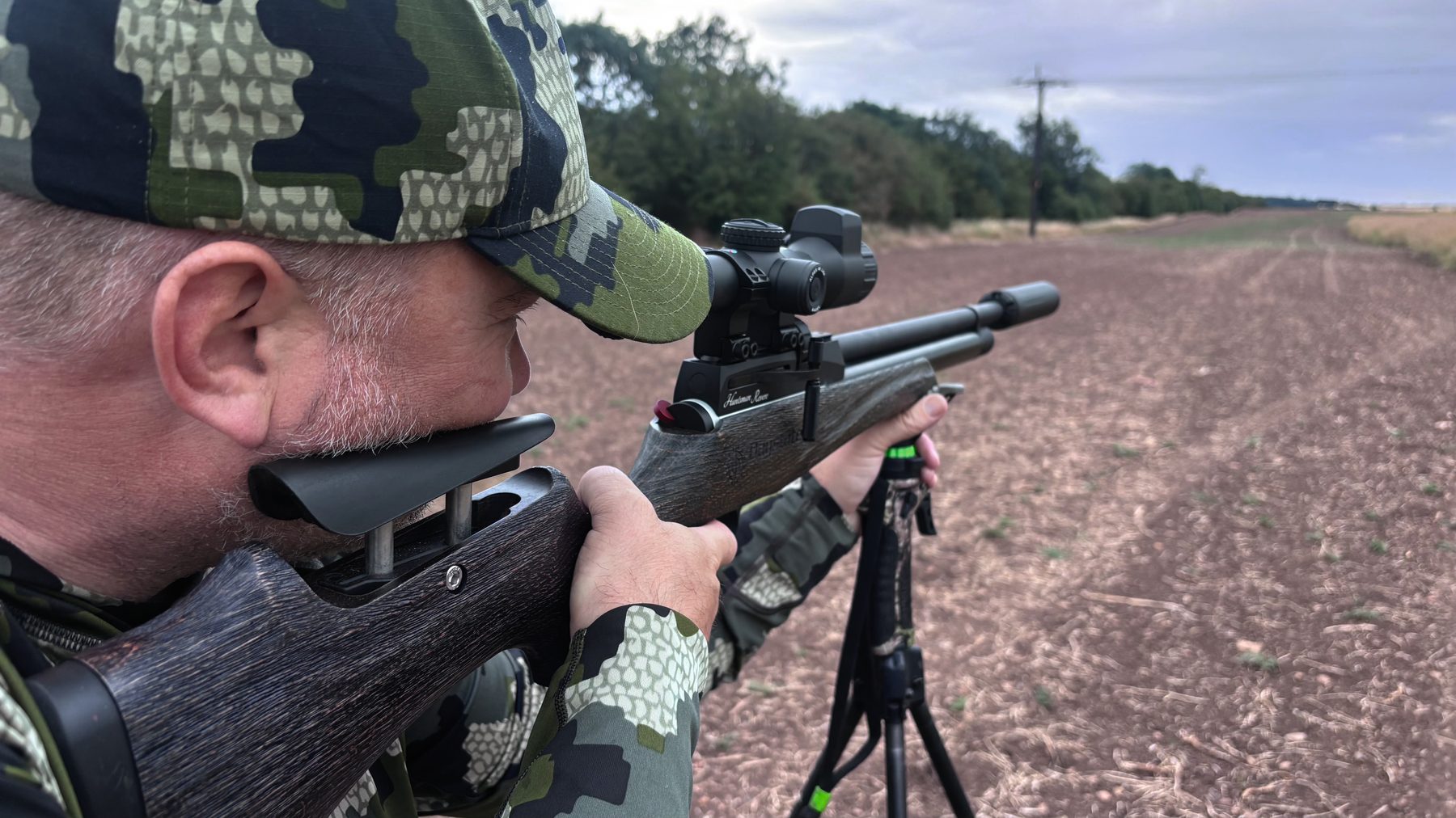 Danny Brookfield aiming an FAC-rated Daystate Huntsman Revere air rifle from tripod shooting sticks