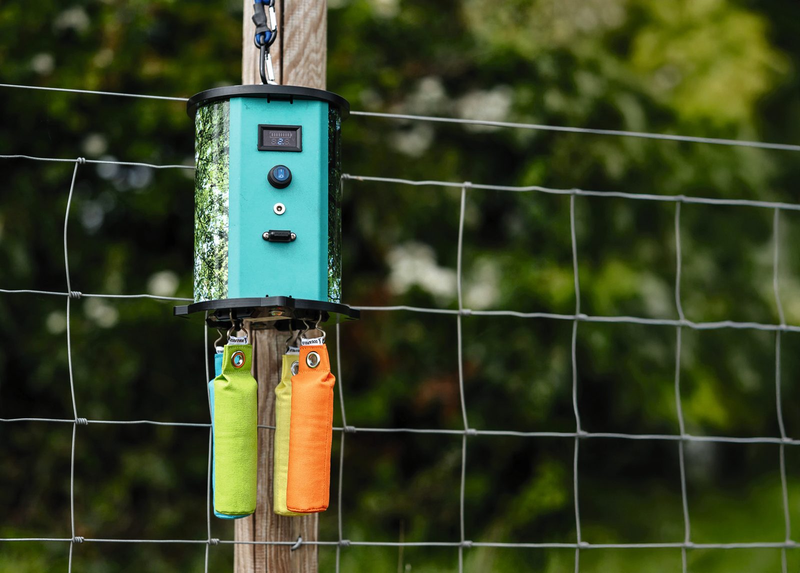 Dog and Field remote dummy dropper mounted on a fence post with dummies attached
