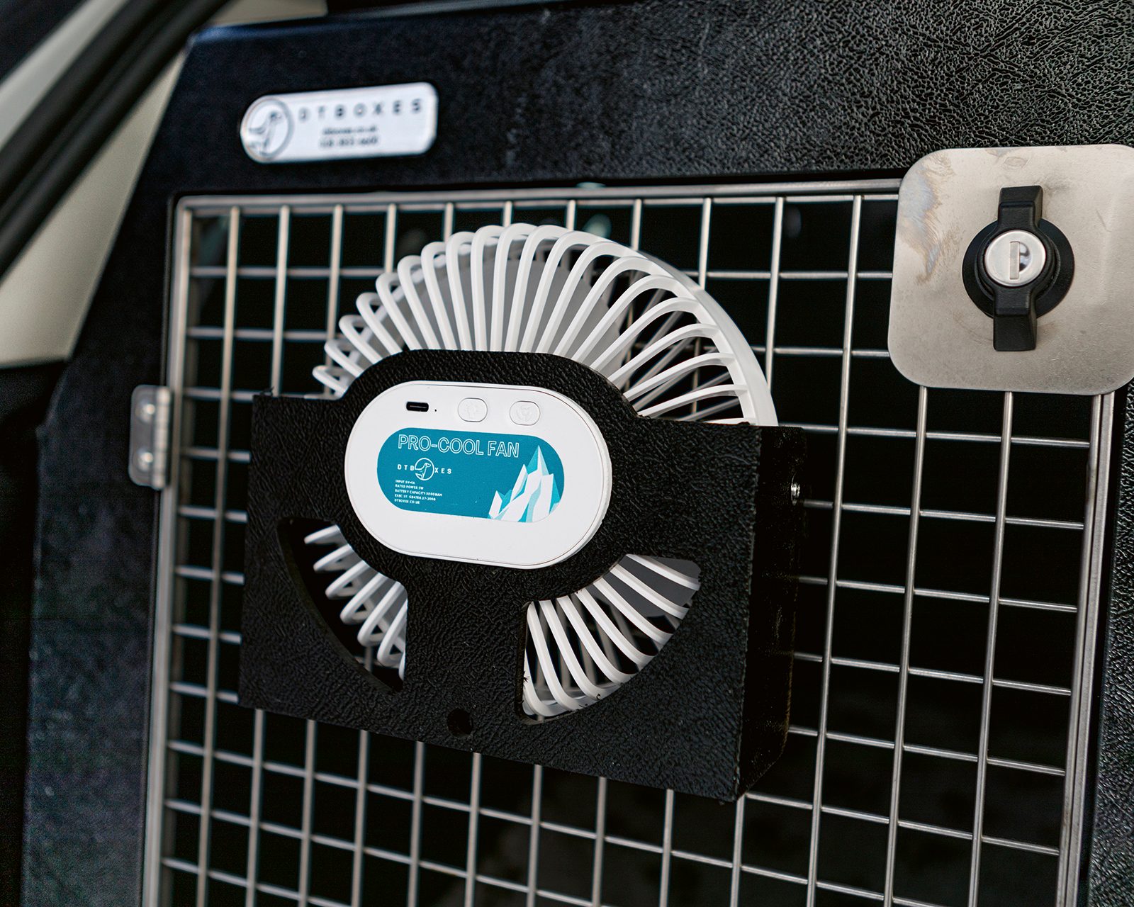 DT Boxes Pro-Cool fan clipped to a dog crate door