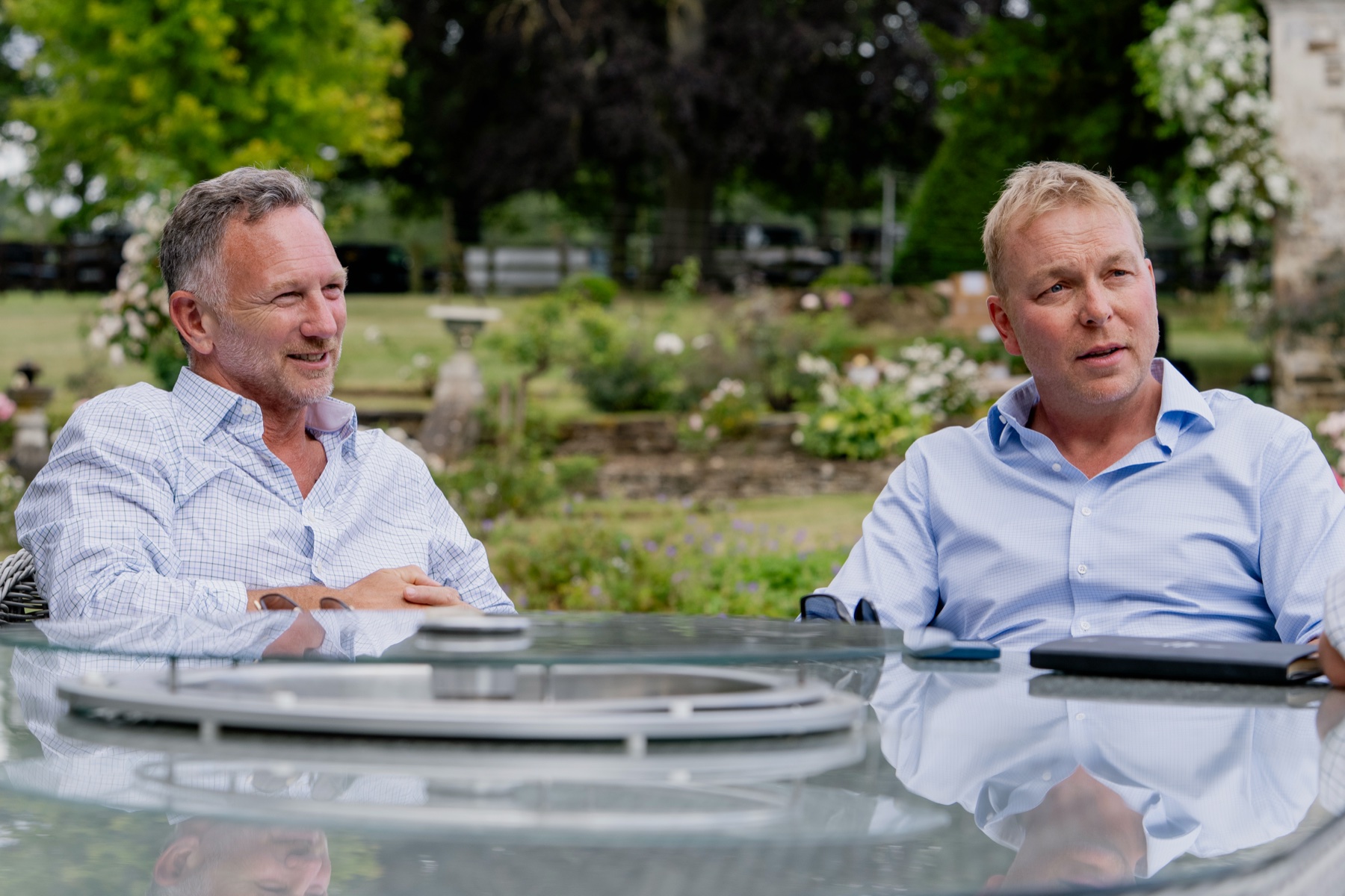 Christian Horner and Sir Chris Hoy sitting at a garden table at Clays for a Cause