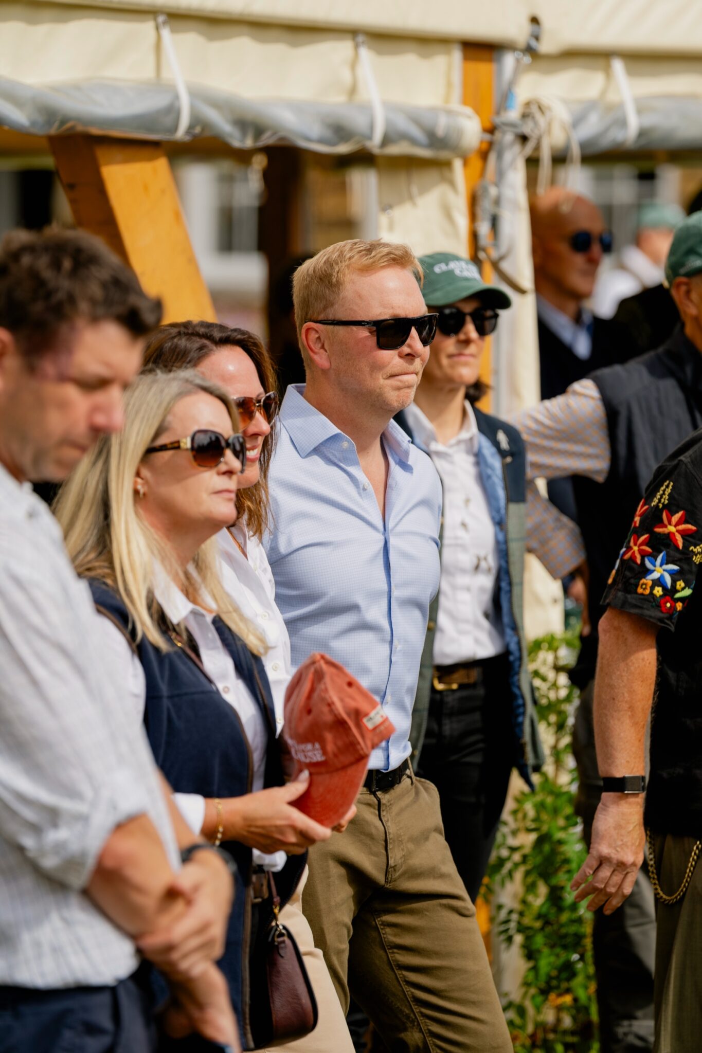 Sir Chris Hoy in sunglasses holding a Clays for a Cause cap among guests at the shoot