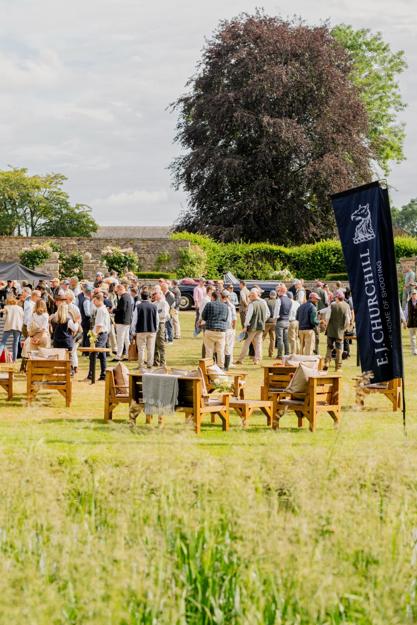 Guests gathering under the copper beech at the Clays for a Cause reception