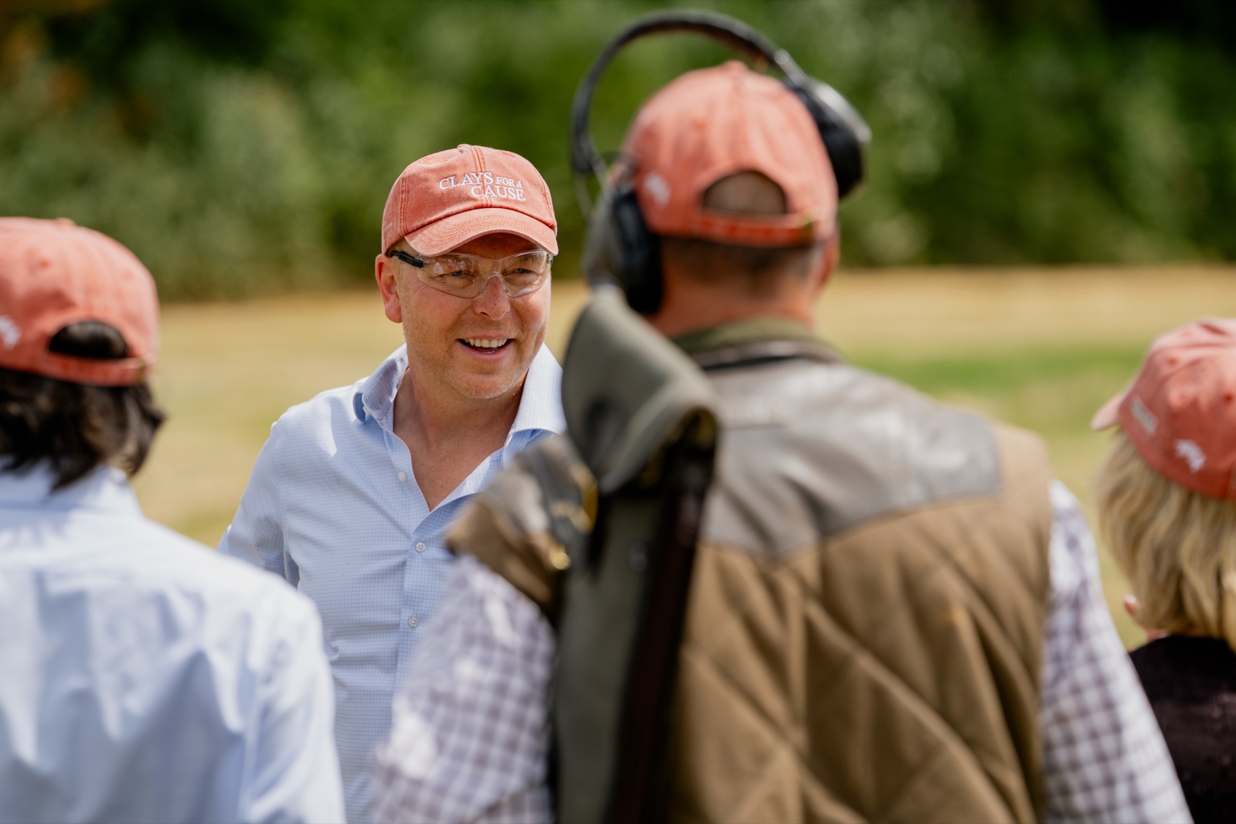 Sir Chris Hoy smiling in a Clays for a Cause cap and shooting glasses between drives