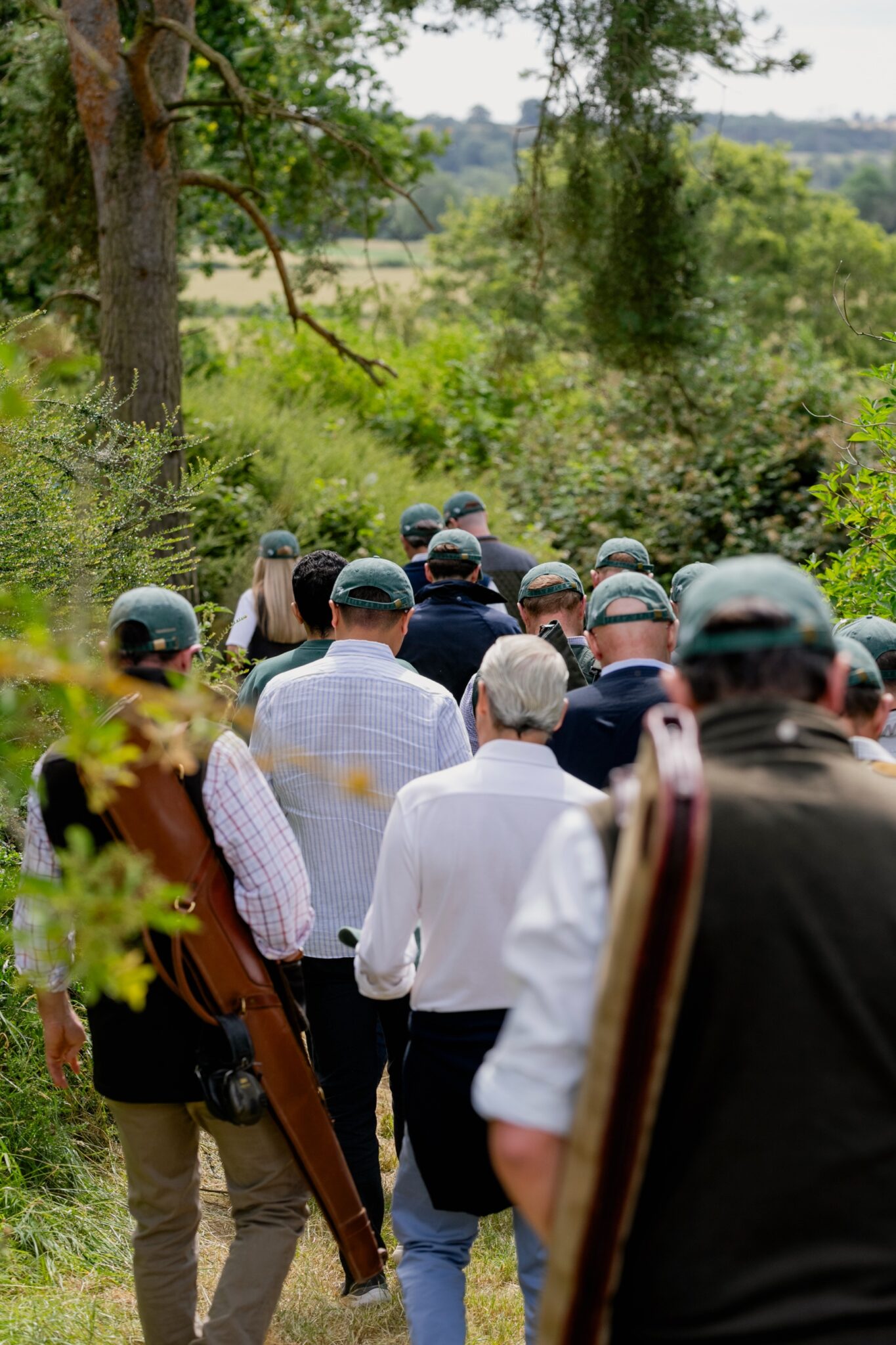 Guns in E.J. Churchill caps walking out to a drive at Clays for a Cause