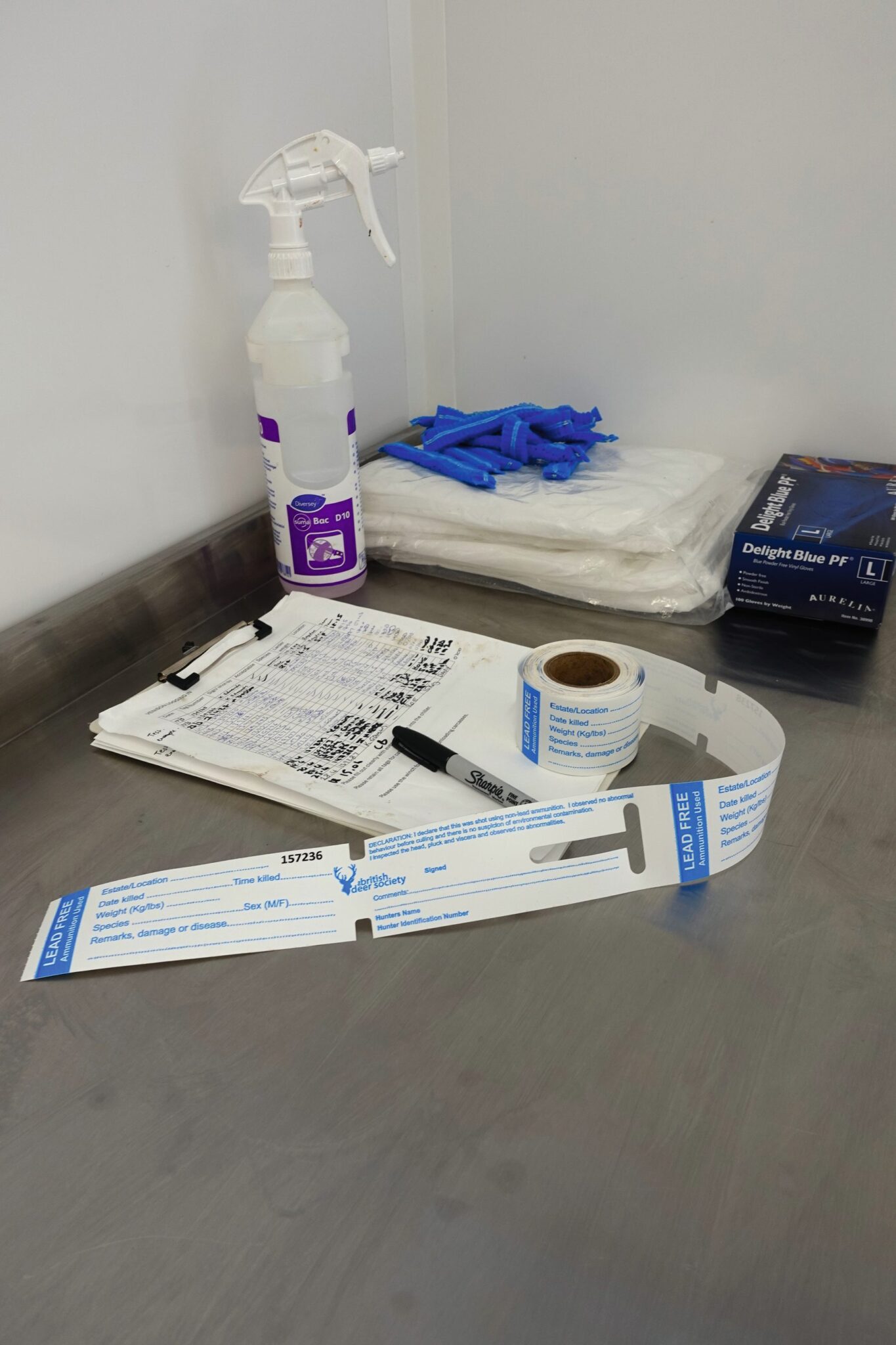 Venison traceability tags, paperwork, gloves and cleaning kit laid out in the estate larder