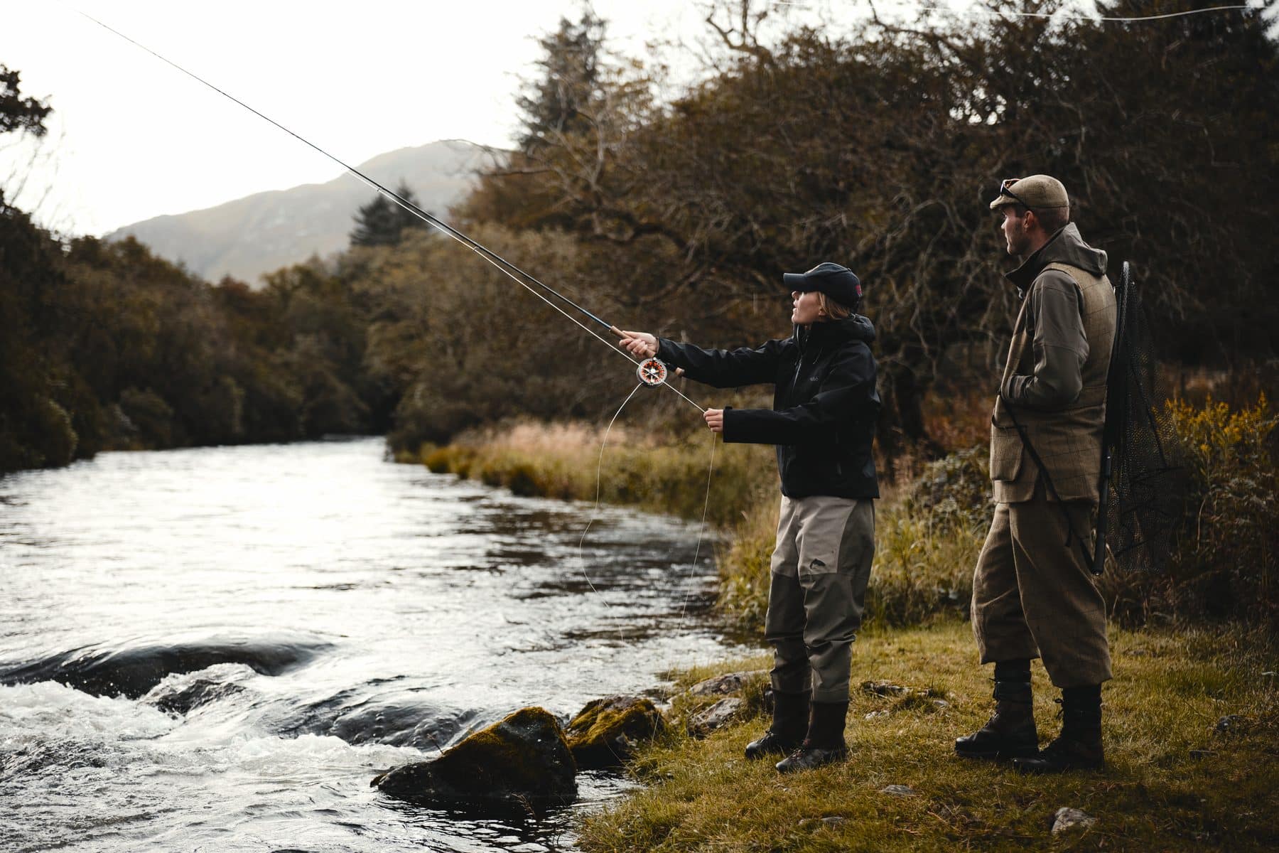 A guest fly fishing the River Ba on Benmore Estate with gillie Angus Youngson standing alongside