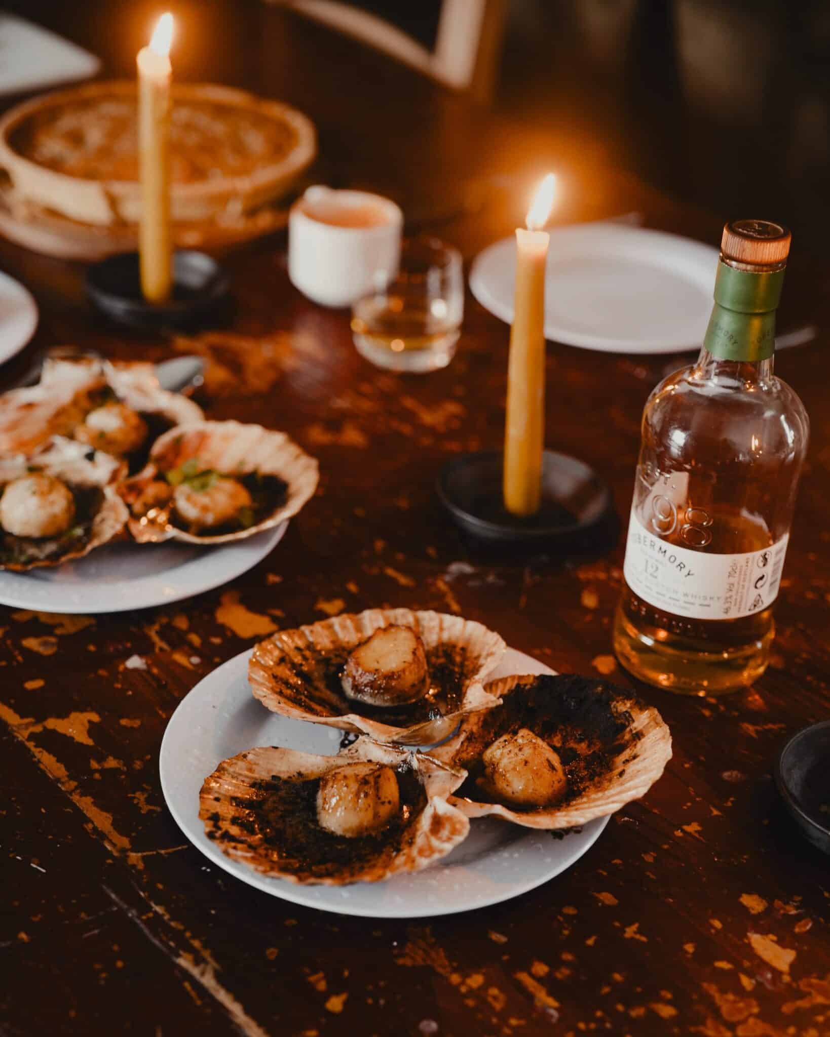 Scallops served on the shell by candlelight at the fishing bothy on Loch Ba, Benmore Estate