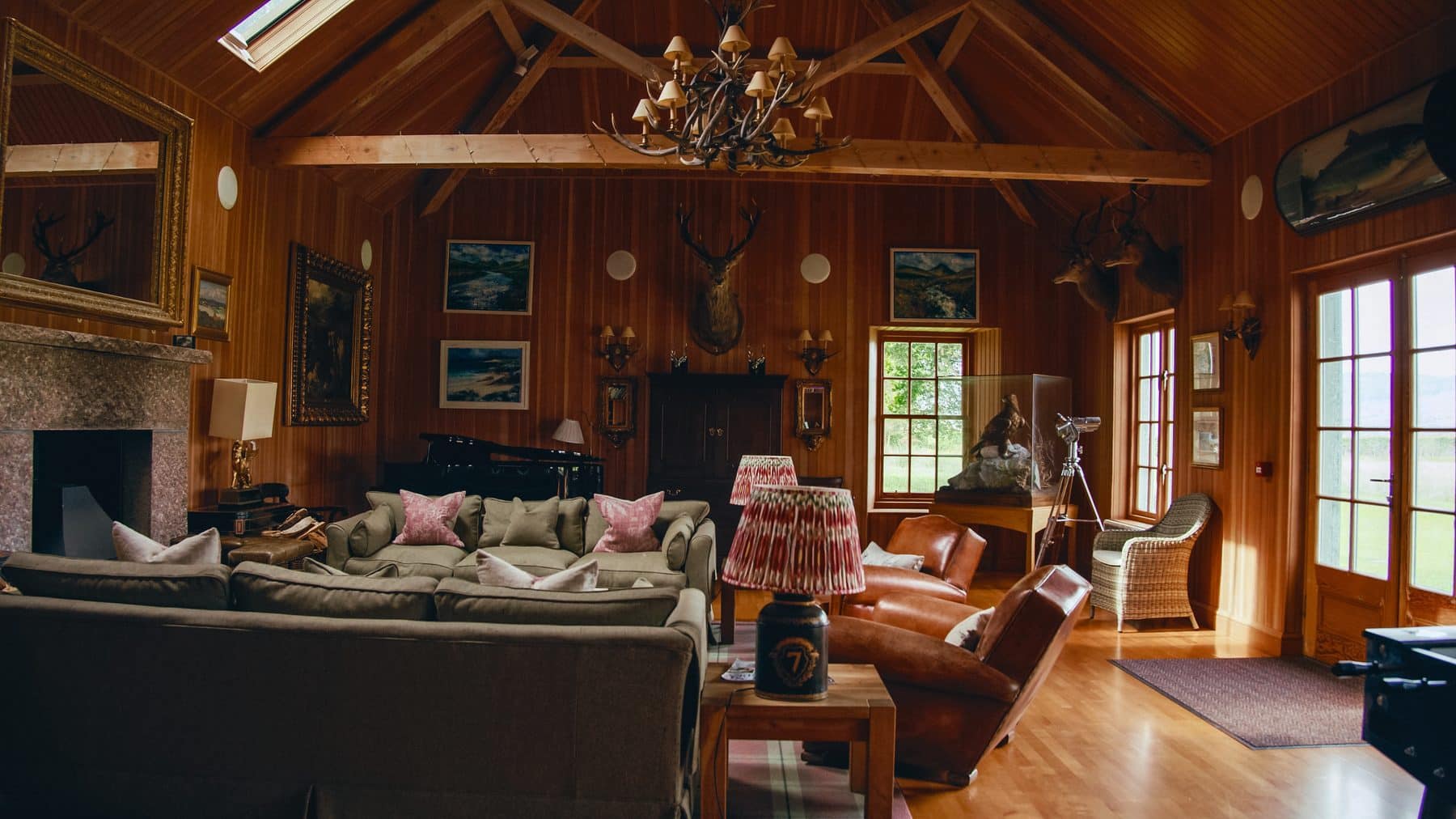 The panelled sitting room at Knock House on Benmore Estate, with a fireplace and stag heads