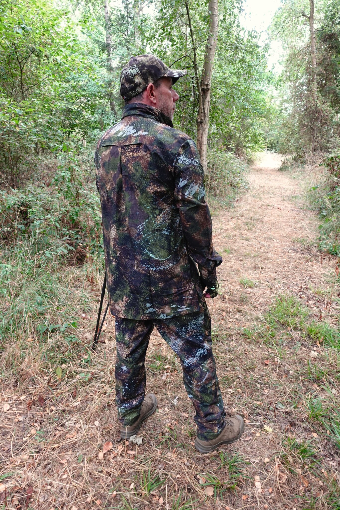 A stalker in a woodland ride from behind, showing the back of the Stoney Creek Fast Hunt Ascent shirt