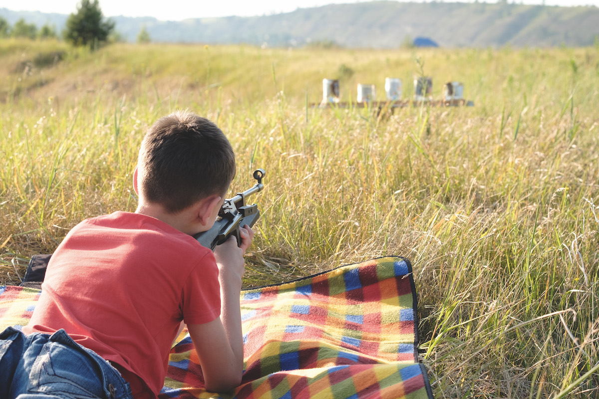 Boy using air rifle